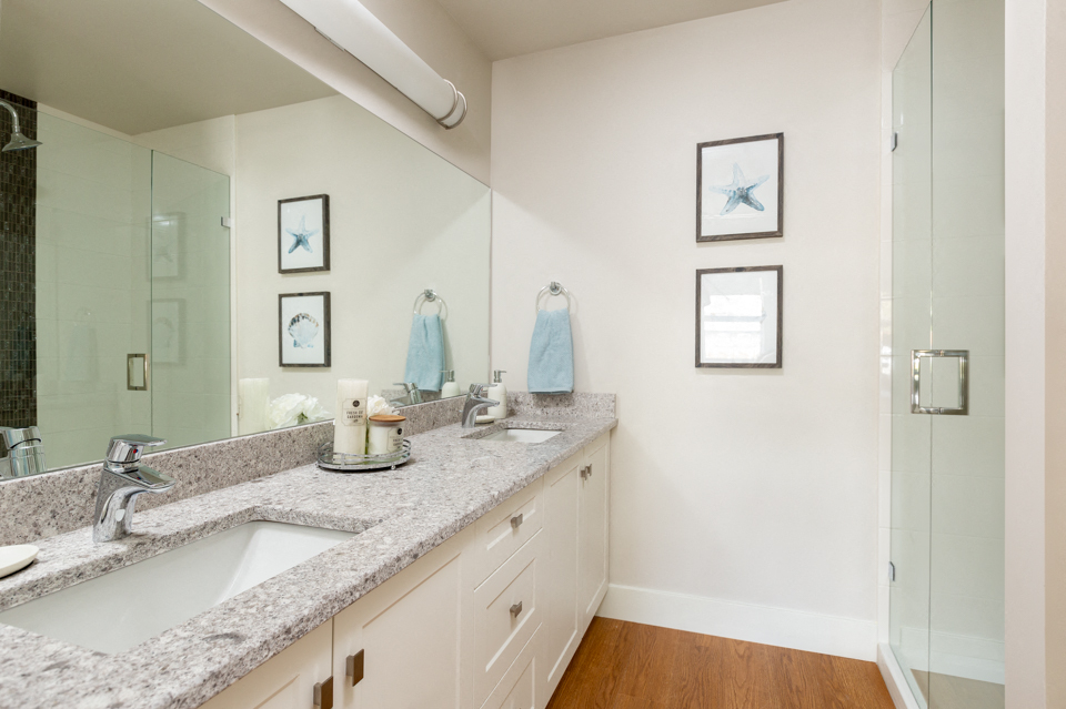 The Conservatory bathroom with double sink and large mirror in Kelowna, BC