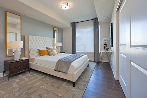 a bedroom with a white bed and a window