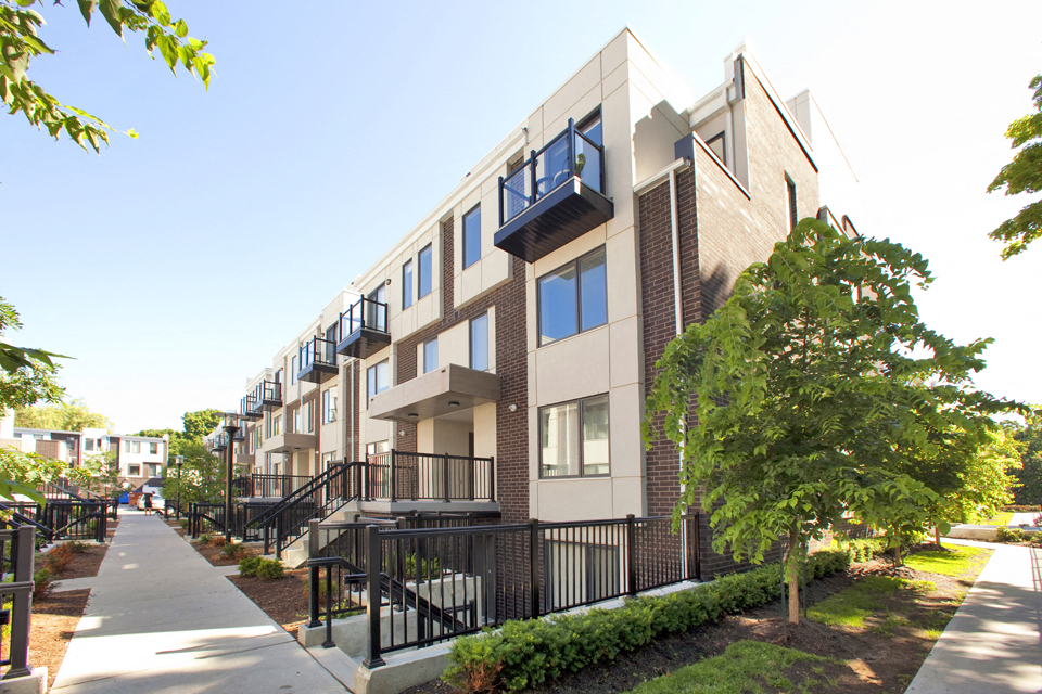 Exterior of Towns on the Ravine with view of sidewalk and lush trees in North York, ON
