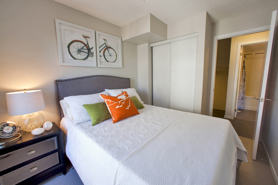 Towns on the Ravine Bedroom with white covers and green and orange pillows