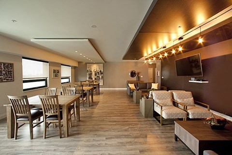 a large dining room with tables and chairs and a television