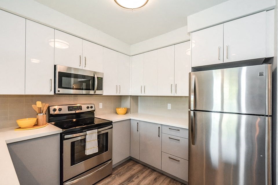 Kitchen with stainless steel appliances and white cabinets in a 1 bed 1 bath variation B in building A at Trio on Belmont in Kitchener, ON