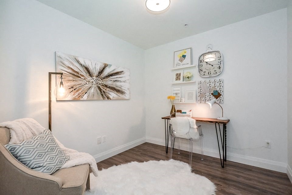 Den, set up as a home office with a desk and chair, in a 2 bed + den 2 bath variation E in building A at Trio on Belmont in Kitchener, ON