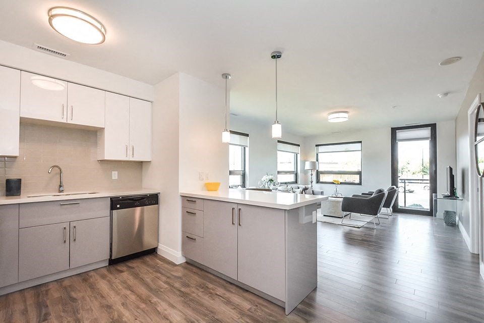 Open floor plan kitchen and living room in a 2 bed + den 2 bath variation E in building A at Trio on Belmont in Kitchener, ON