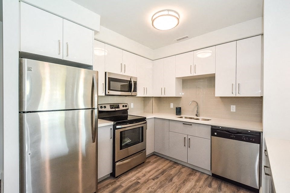 Kitchen with stainless steel appliances and white cabinets in a 2 bed + den 2 bath variation E in building A at Trio on Belmont in Kitchener, ON