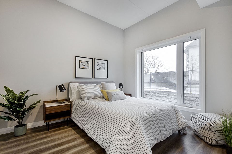 a bedroom with a bed and a large window at Vale Station Apartments in Waterloo ON