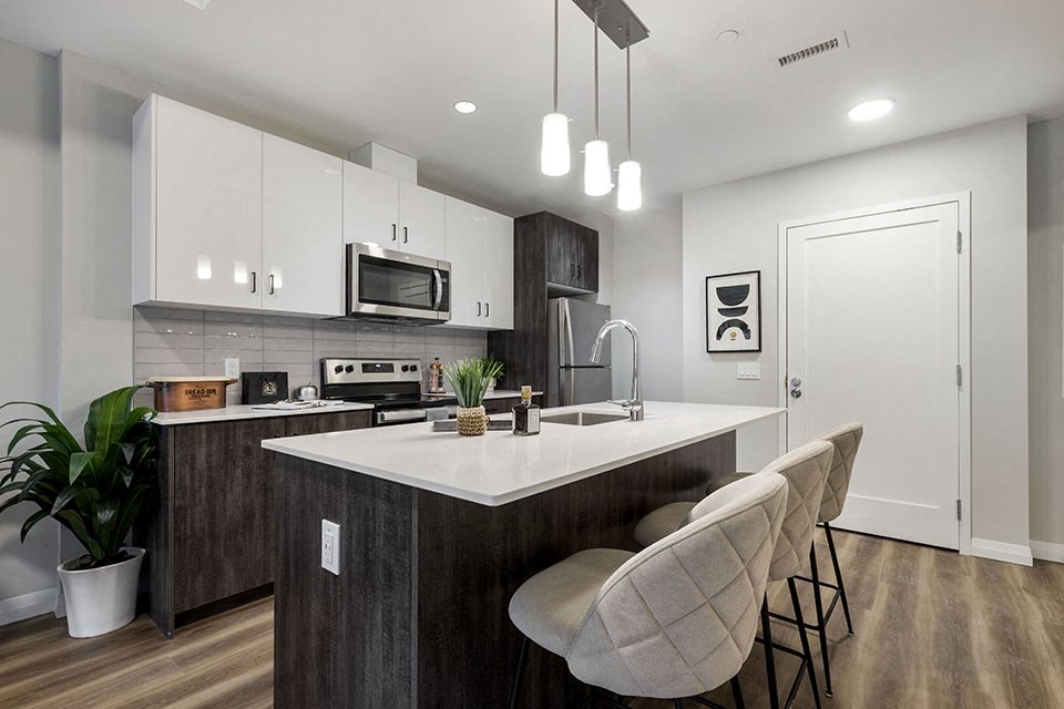 an open kitchen with an island and chairs at Vale Station Apartments in Waterloo ON