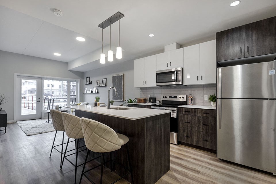 a kitchen with a large island and a stainless steel appliances at Vale Station Apartments in Waterloo ON