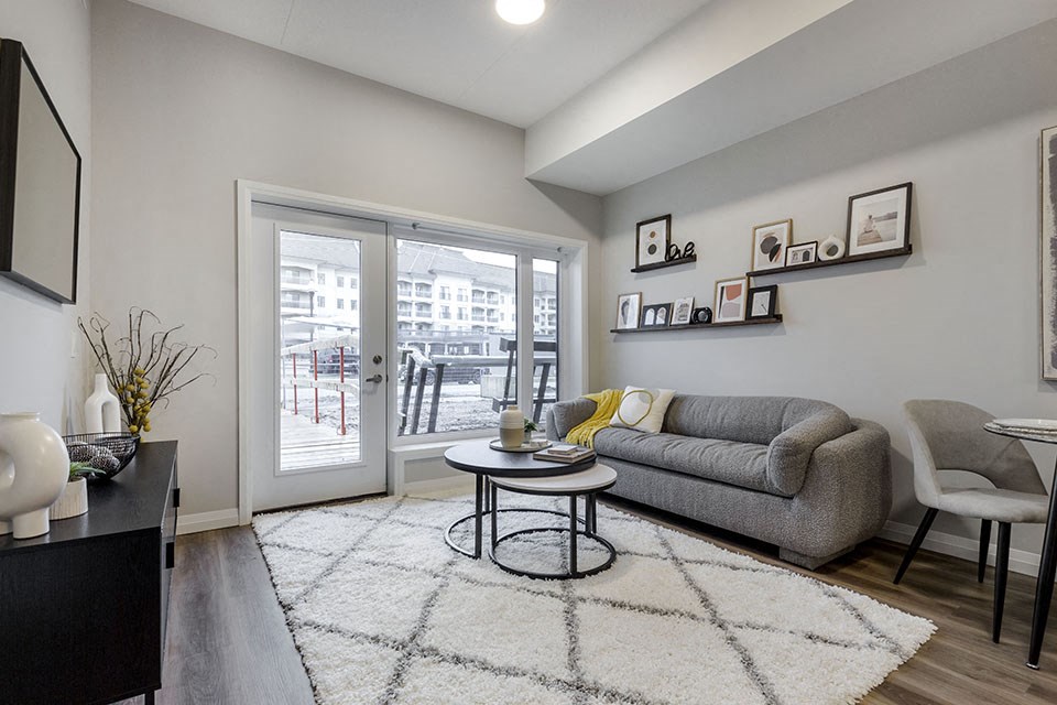 a living room with a couch and a door to a balcony at Vale Station Apartments in Waterloo ON