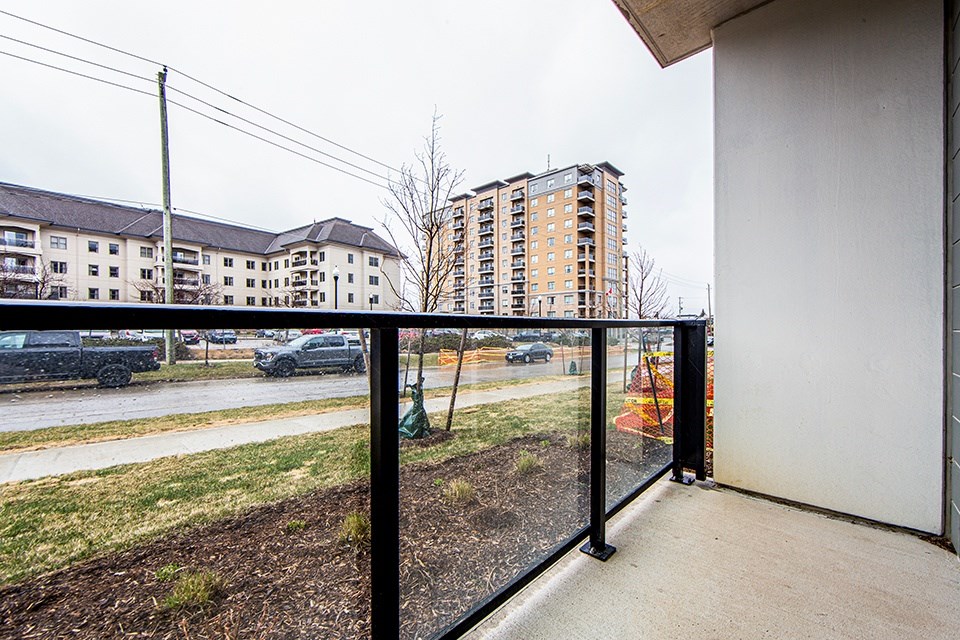 Ground floor patio with glass railing overlooking the street in a 2 bedroom 2 bathroom variation C layout at Vale Station Apartments in Waterloo, Ontario