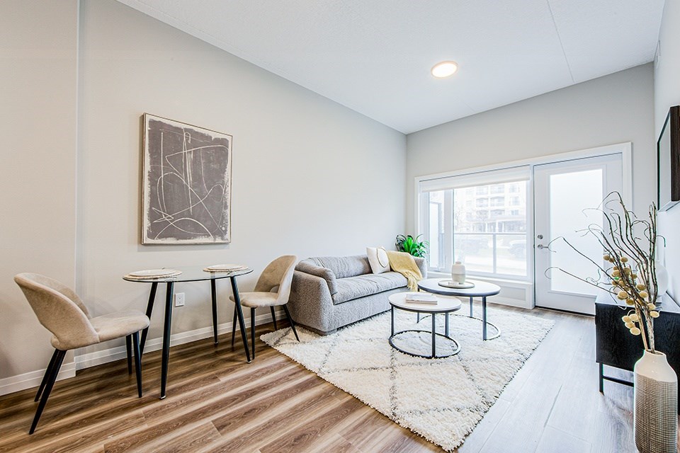 Dining and living area with a two-seater dining table and chairs, couch and two round coffee tables in a 2 bedroom 2 bathroom variation C layout at Vale Station Apartments in Waterloo, Ontario