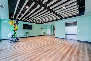 Yoga and Pilates studio with a wood-slat ceiling and elevator connected to a gym located on the floor below at Vale Station Apartments in Waterloo, Ontario