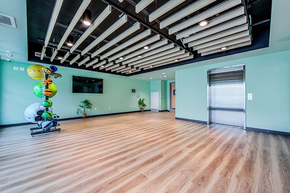 Yoga and Pilates studio with a wood-slat ceiling and elevator connected to a gym located on the floor below at Vale Station Apartments in Waterloo, Ontario