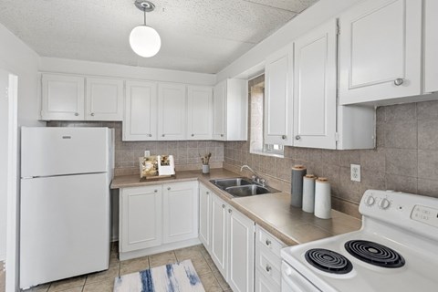 Kitchen with fridge, stove, cabinetry and window at Village Tower Toronto ON