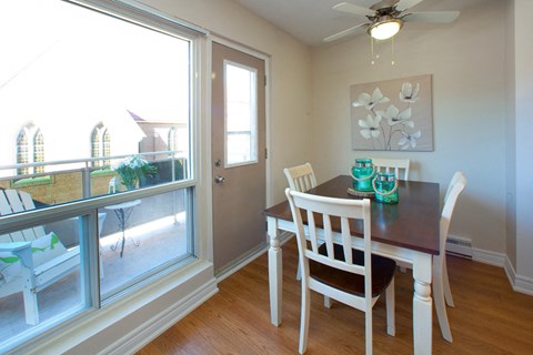 A dining room with a table and chairs.