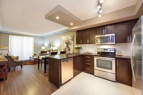 a large kitchen and dining room with stainless steel appliances and wooden cabinets