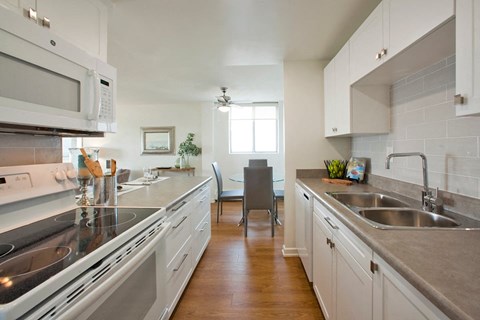 A kitchen with a white stove and a white microwave.