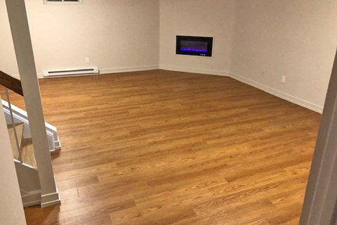 a living room with wooden floors and a tv on the wall