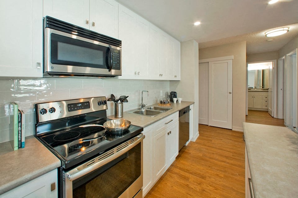 Squire Court kicthen with full range stove and over-the-range microwave in St. Catharines, ON