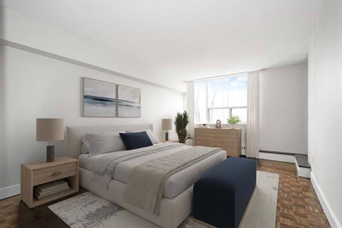 A bedroom with a large bed and a nightstand with a lamp.