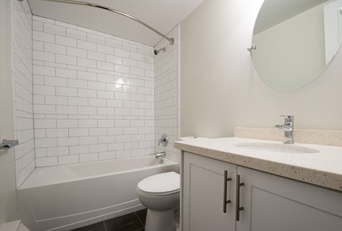 A white bathroom with a toilet, sink, and bathtub.