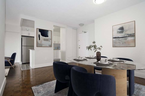 A dining room with a table set for two and a blue chair.