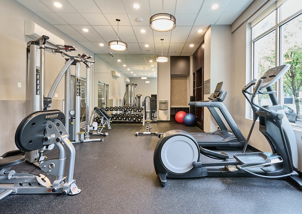 a gym with treadmills and other exercise equipment at Wesley Place Apartments in Vancouver British Columbia