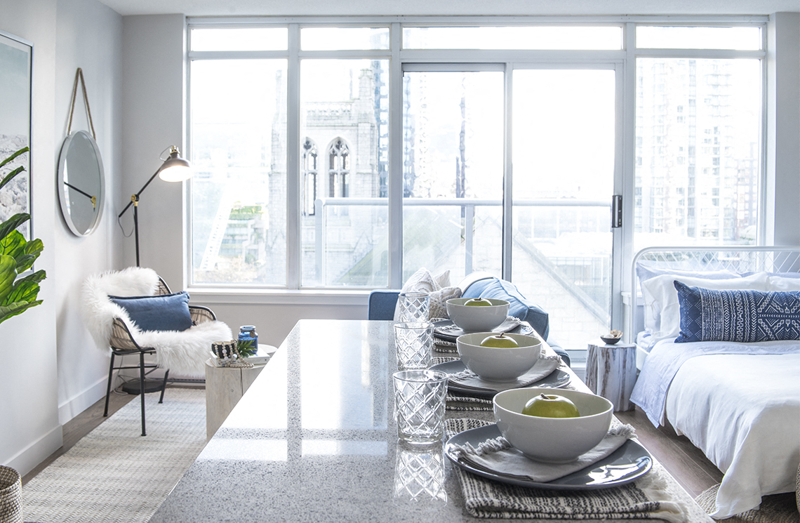 a living room with a large window and a table with bowls on it