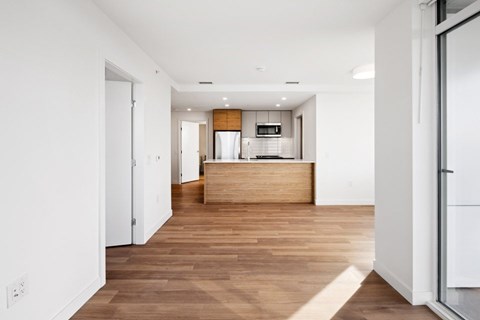 A modern kitchen with a wooden island and white walls.