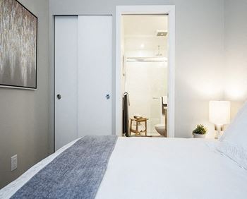 a bedroom with a bed and a door to a bathroom