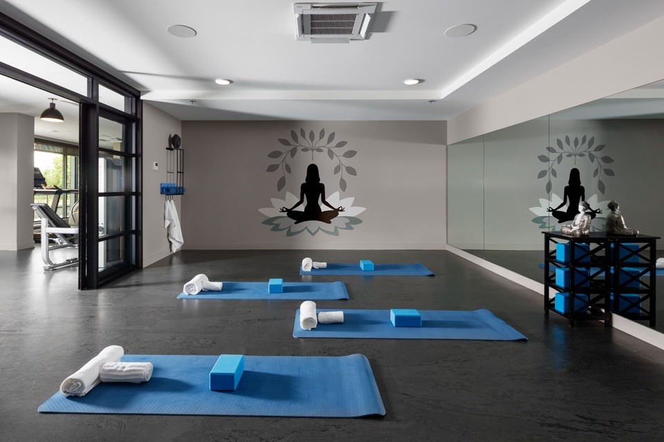 A yoga studio with blue mats and yoga blocks at The Ambrosi in Kelowna, BC.