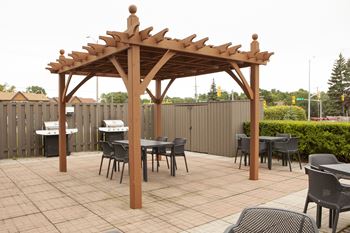 a patio with a wooden gazebo and tables and chairs