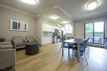 a living room and dining room with a table and chairs