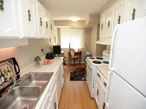 A kitchen with white cabinets and appliances.