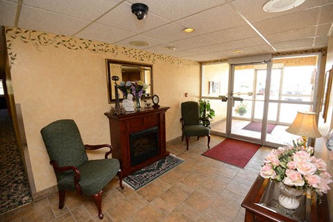 a living room with a fireplace and chairs