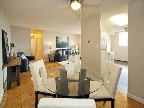 Highpoint Barrie Dining room with glass table and four white chairs that has a view of the living room and balcony in Barrie, ON