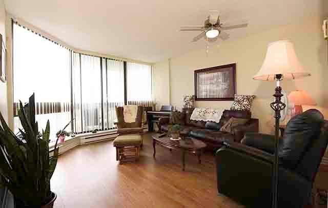 Prince William Apartments spacious living room with large window and balcony access in Bellville, ON