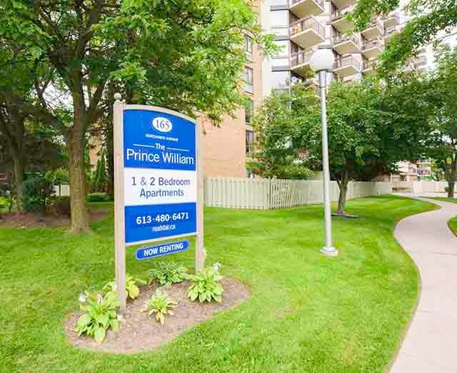 Prince William Apartments property sign on front lawn in Bellville, ON