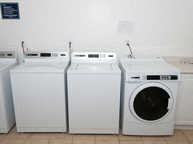 Park Place Shared laundry room with three washers and a dryer in Bradford, ON