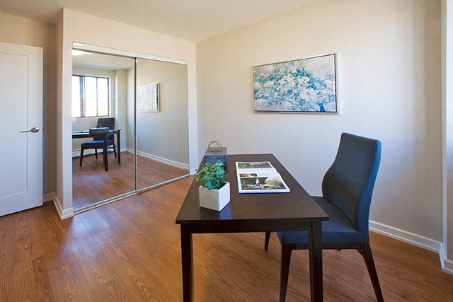 Mountain View Study room with a dark wood desk and chair. A mirrored door closet is on the left in Collingwood, ON