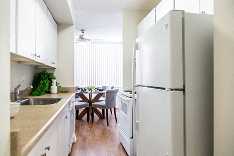 a kitchen with a refrigerator and a table with chairs
