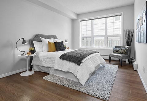 A bedroom with a large bed and a chair.
