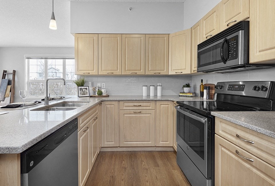 A kitchen with wooden cabinets and black appliances.