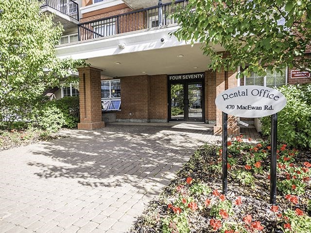 The entrance to the Four Seventy dental office is framed by a brick wall and a flower bed.