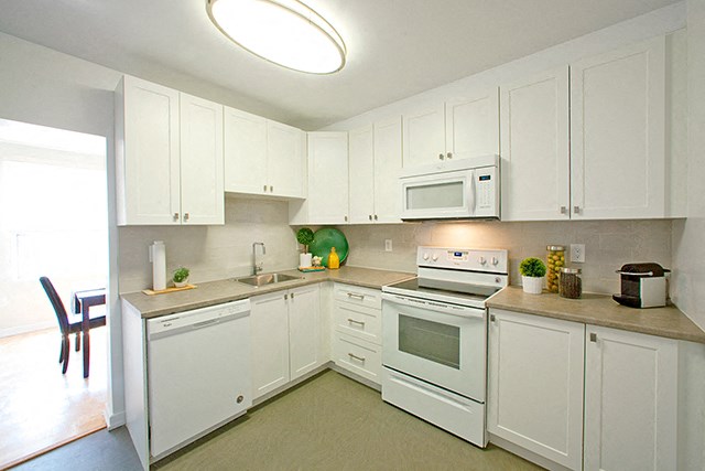 Fairway Towers kitchen with dishwasher, full range stove, and microwave in Sarnia, ON