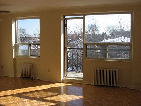 an empty living room with large windows and