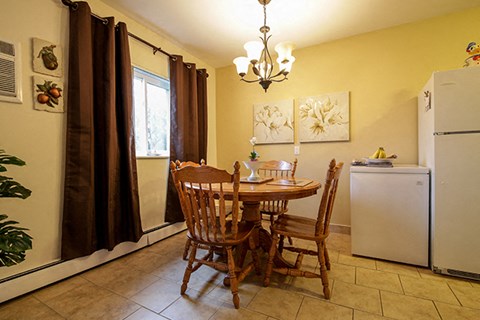 a kitchen with a dining table and a refrigerator