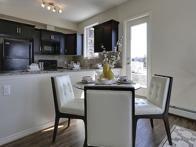 Airdrie Place in Airdrie, AB Open concept kitchen-dining area with balcony access