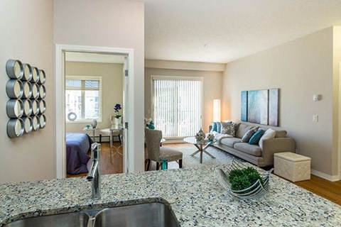 A kitchen with a granite counter top and a sink.