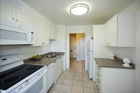 a kitchen with white cabinets and a white stove and a microwave